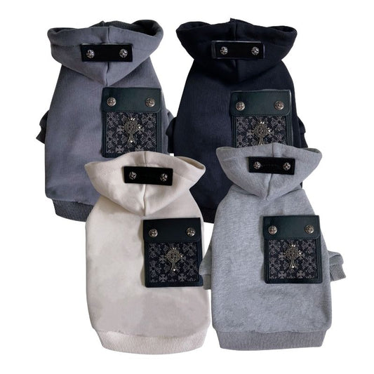 Four Chrome Hearts dog coats in gray, black, and white with decorative patches on a white background